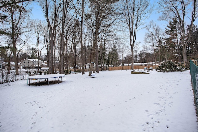 yard covered in snow featuring a trampoline