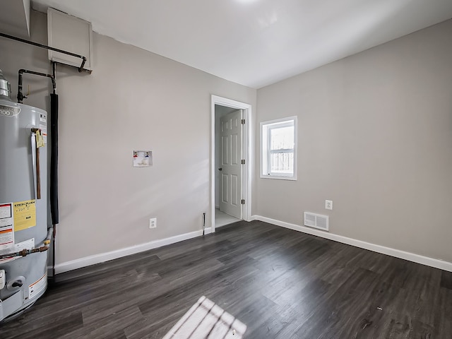 empty room with dark hardwood / wood-style floors and water heater