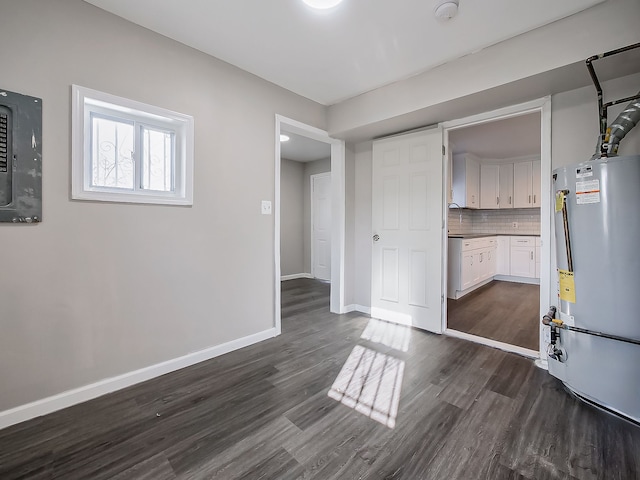 interior space with tasteful backsplash, white cabinetry, dark hardwood / wood-style floors, and water heater