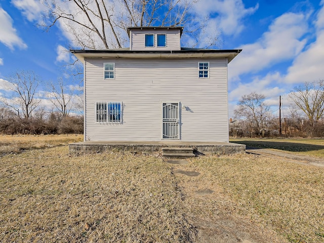 back of house with a lawn