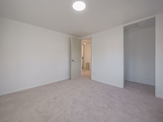 unfurnished bedroom featuring light carpet and a closet