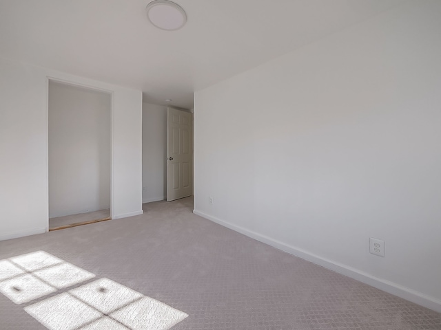 unfurnished room featuring light colored carpet