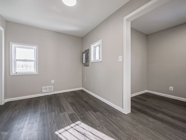 spare room with dark hardwood / wood-style floors and a healthy amount of sunlight