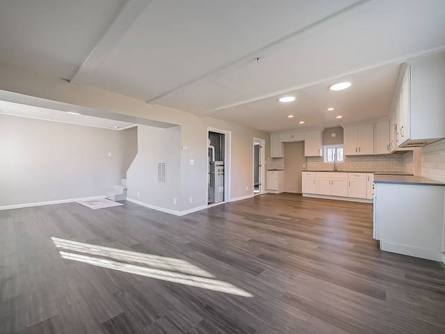 kitchen featuring white cabinets, decorative backsplash, dark hardwood / wood-style flooring, and sink