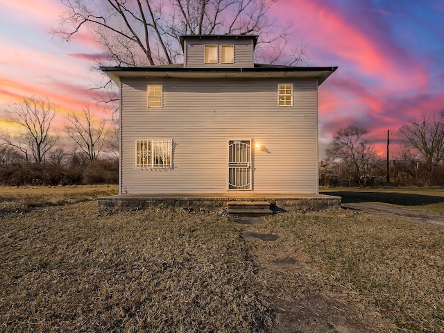 back house at dusk with a yard