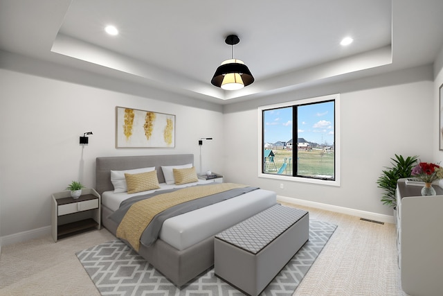 carpeted bedroom featuring a raised ceiling