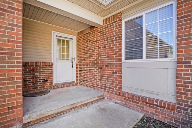 view of exterior entry with brick siding