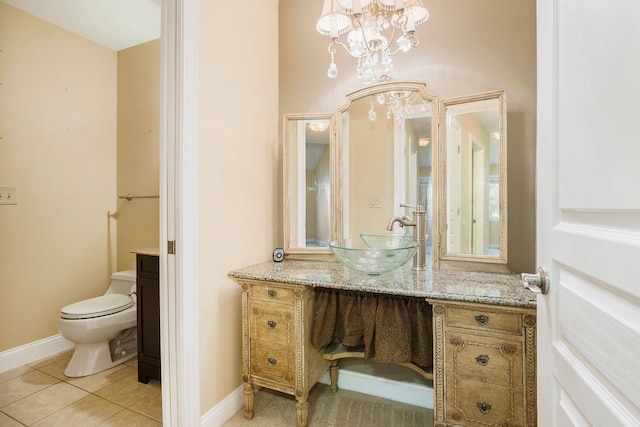 bathroom featuring baseboards, vanity, toilet, and tile patterned floors