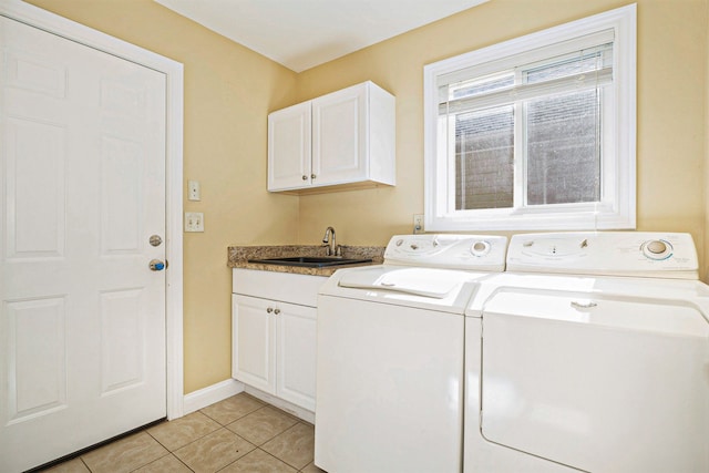 laundry room featuring cabinet space, baseboards, washing machine and dryer, a sink, and light tile patterned flooring