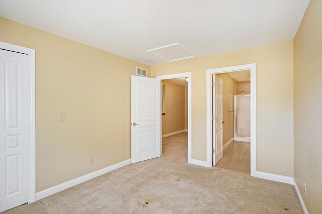 unfurnished bedroom featuring attic access, light colored carpet, visible vents, and baseboards