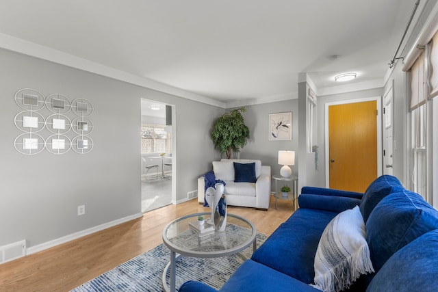 living room with light hardwood / wood-style floors and crown molding