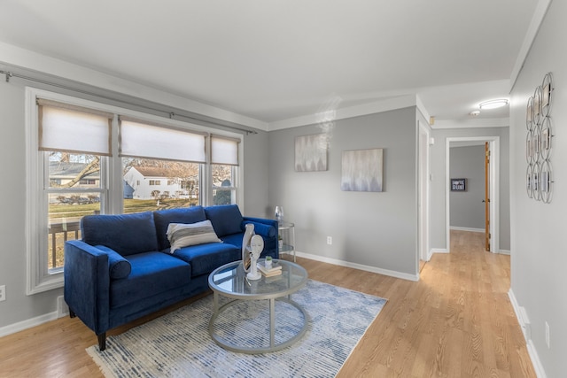 living room featuring light hardwood / wood-style flooring and ornamental molding