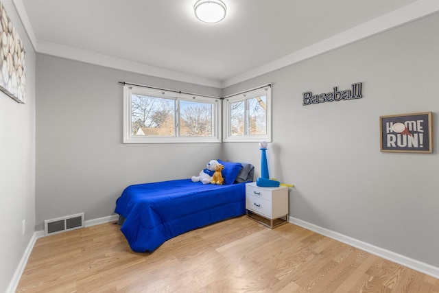 bedroom featuring hardwood / wood-style floors and crown molding