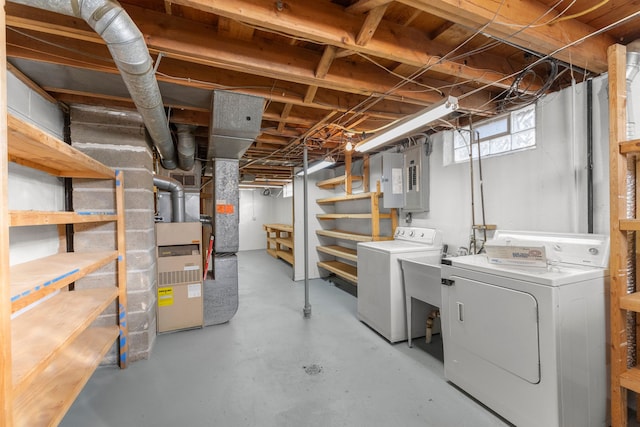 basement with electric panel, heating unit, and independent washer and dryer