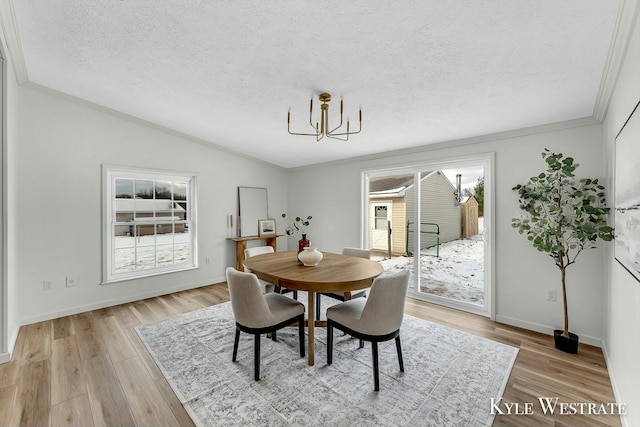 dining room with a chandelier, a textured ceiling, light hardwood / wood-style floors, and plenty of natural light