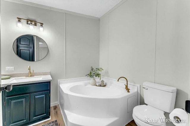 bathroom with ornamental molding, toilet, a bathtub, vanity, and hardwood / wood-style flooring