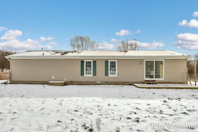 view of snow covered rear of property