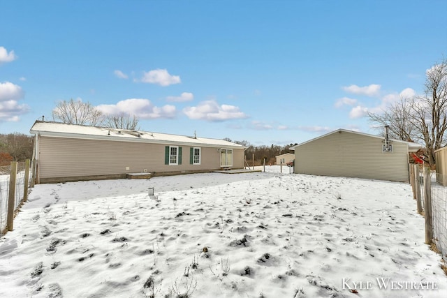 view of snow covered back of property