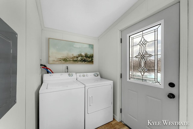 laundry area featuring light hardwood / wood-style flooring, ornamental molding, and washing machine and clothes dryer