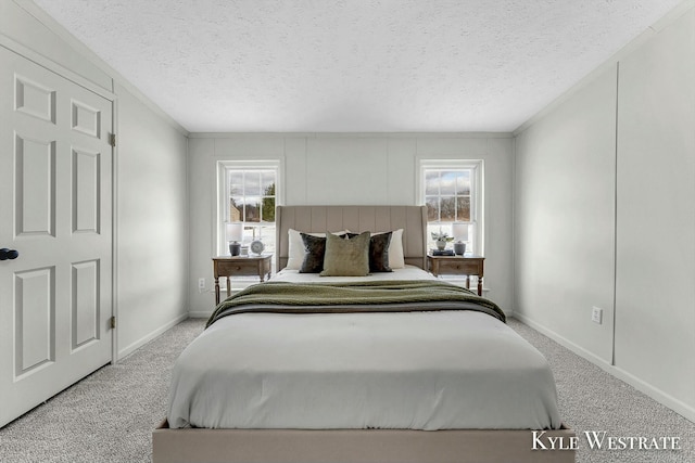 bedroom with multiple windows, light colored carpet, and a textured ceiling