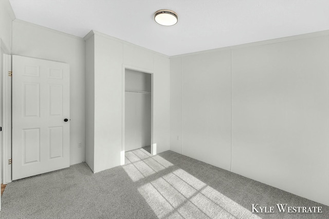 unfurnished bedroom with light colored carpet and a closet