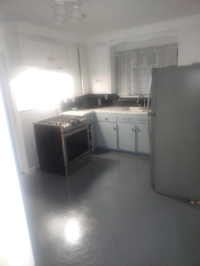 kitchen featuring white cabinets, refrigerator, range, and sink