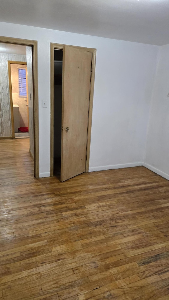 empty room with baseboards and wood finished floors