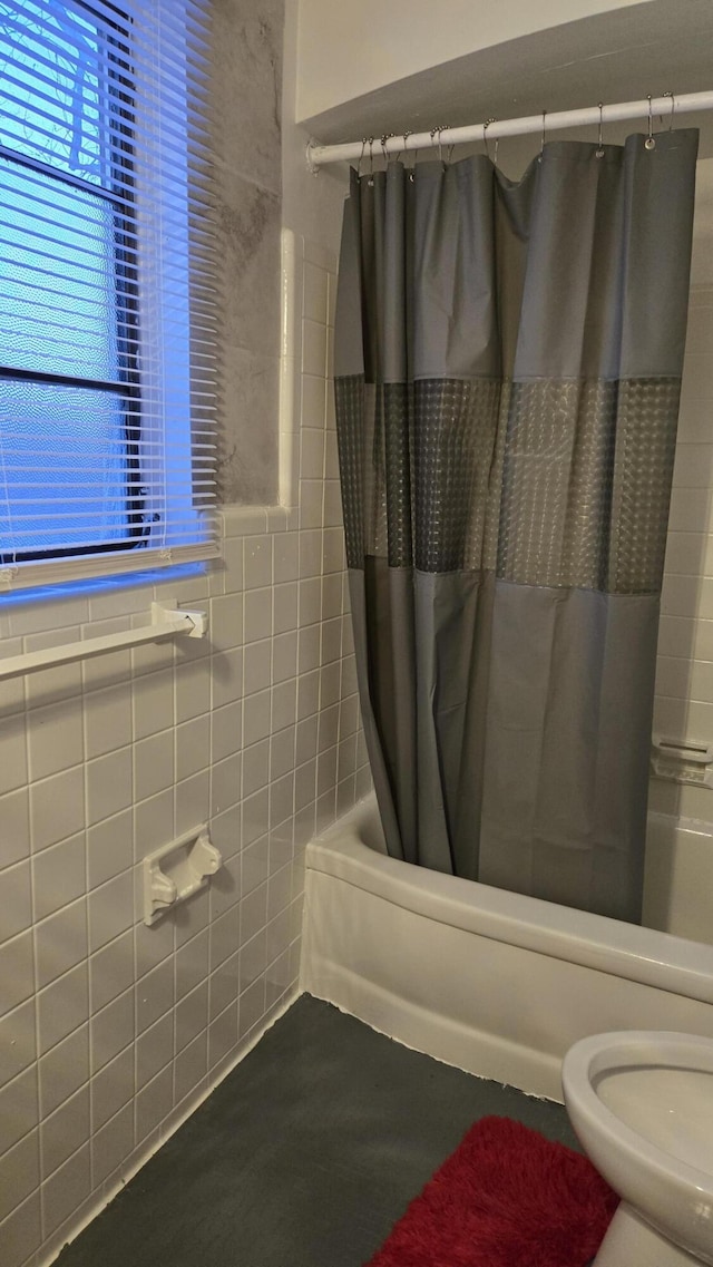 bathroom featuring shower / bath combo with shower curtain, toilet, and tile walls