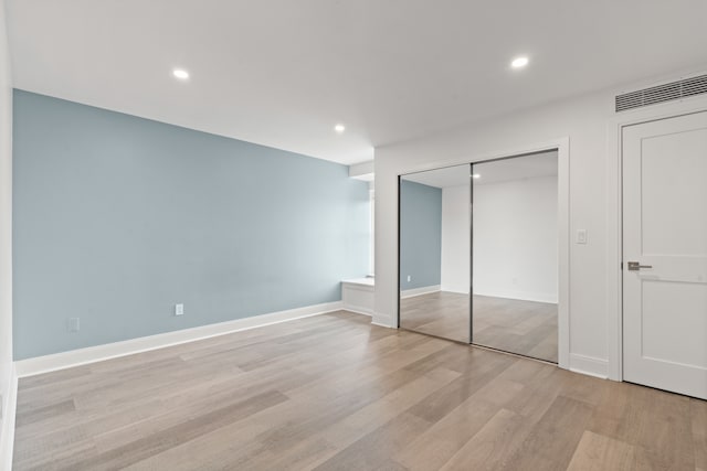 unfurnished bedroom with light wood-type flooring and a closet