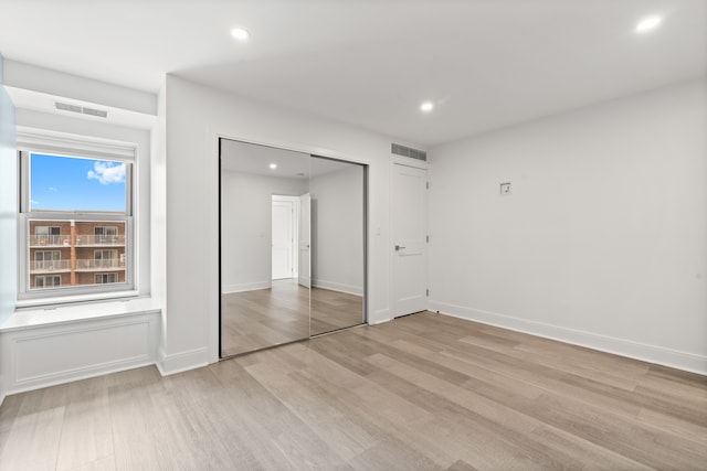 unfurnished bedroom featuring a closet and light wood-type flooring