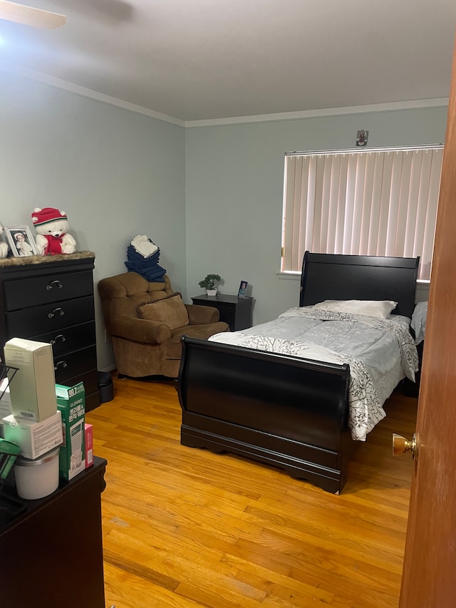 bedroom with crown molding and light hardwood / wood-style flooring