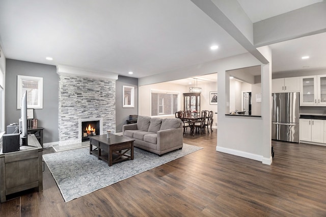 living room with a fireplace and dark wood-type flooring