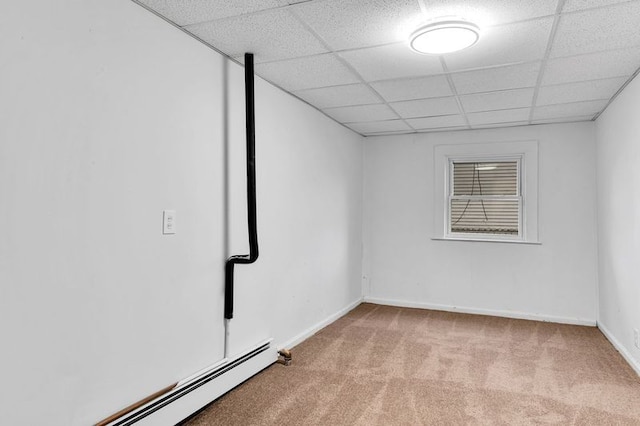 spare room featuring a paneled ceiling, baseboard heating, and light carpet