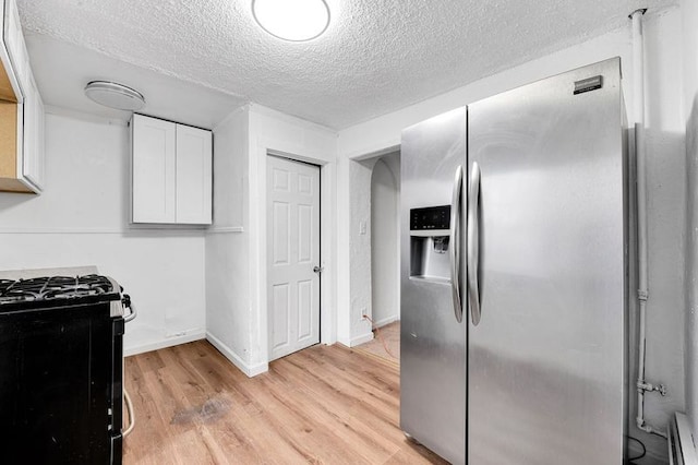 kitchen featuring white cabinetry, stainless steel fridge with ice dispenser, black gas stove, a textured ceiling, and light wood-type flooring