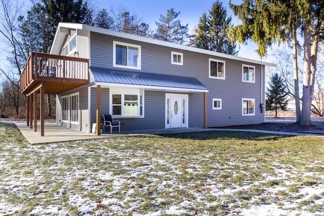 snow covered property featuring a wooden deck and a patio