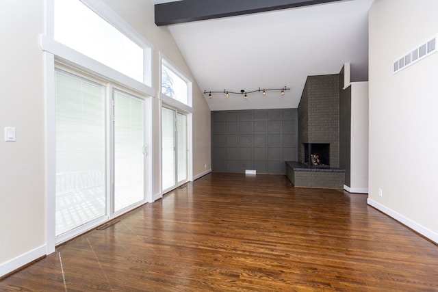 unfurnished living room featuring beamed ceiling, high vaulted ceiling, dark hardwood / wood-style floors, and a brick fireplace