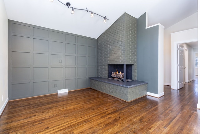 unfurnished living room with lofted ceiling, dark hardwood / wood-style floors, and a brick fireplace