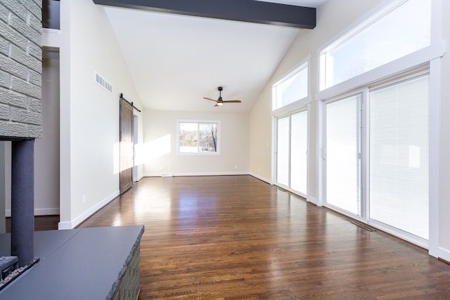 unfurnished living room featuring high vaulted ceiling, ceiling fan, a barn door, beam ceiling, and dark hardwood / wood-style flooring