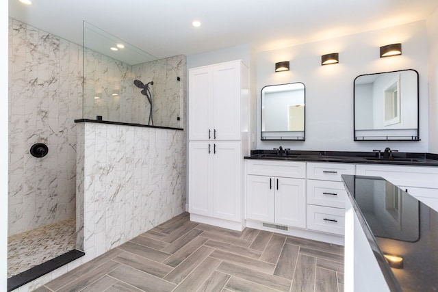 bathroom featuring a tile shower and vanity