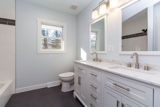 bathroom featuring vanity, toilet, and a wealth of natural light