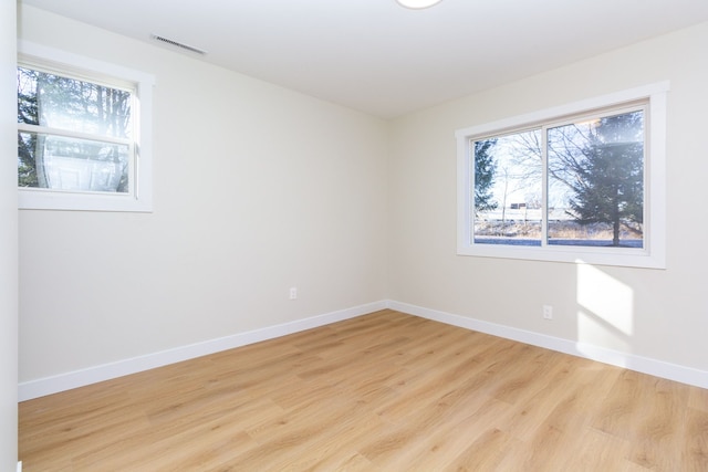 unfurnished room featuring plenty of natural light and light hardwood / wood-style floors