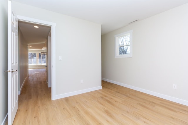 spare room with plenty of natural light and light hardwood / wood-style flooring