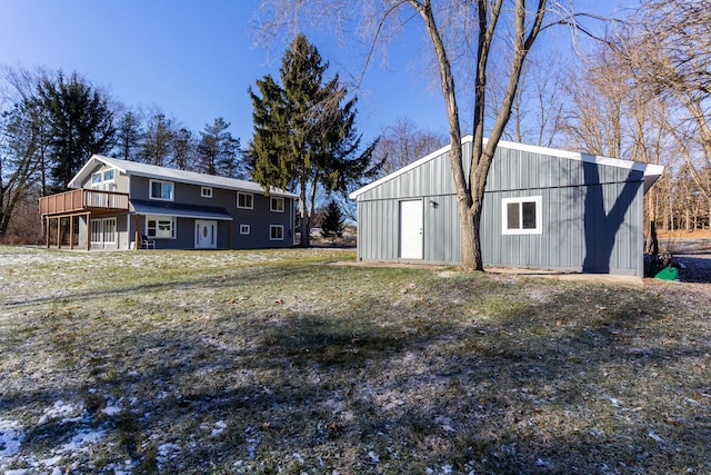 rear view of property with an outdoor structure and a deck