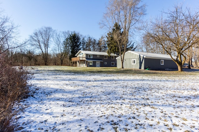 yard covered in snow featuring a deck and an outdoor structure