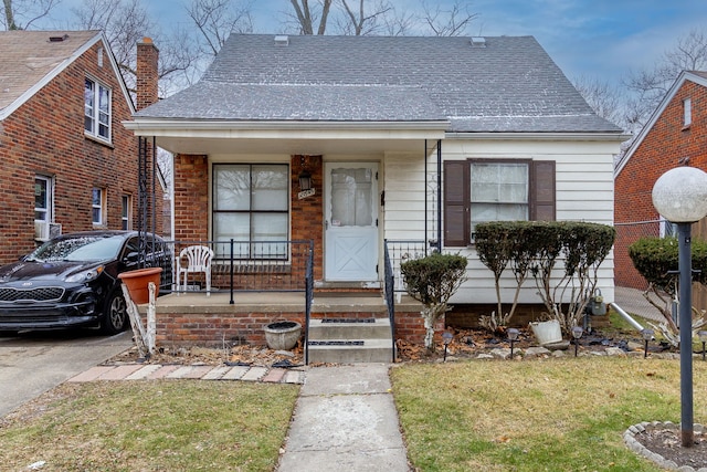 bungalow-style house with covered porch and a front lawn