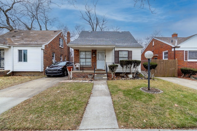 bungalow with covered porch and a front yard