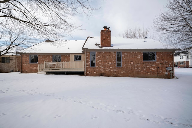 snow covered property with a wooden deck