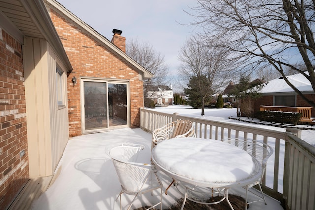 snow covered patio featuring a wooden deck