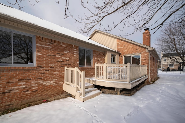 snow covered property featuring a wooden deck