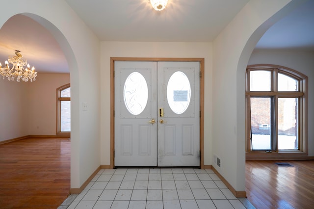 foyer entrance featuring a chandelier and light wood-type flooring